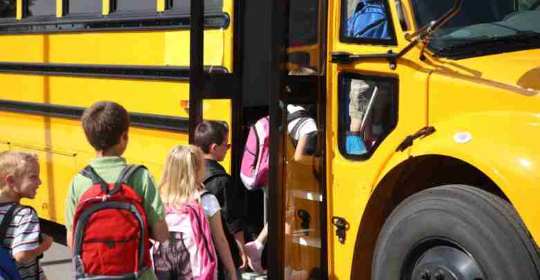 Elementary school students getting on school bus