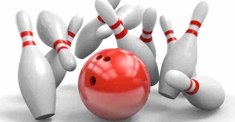 Red bowling ball knocking over pins in a perfect strike