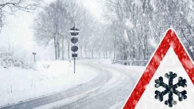 Snowy curvy road with traffic sign