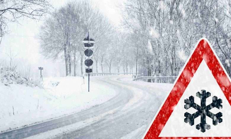 Snowy curvy road with traffic sign