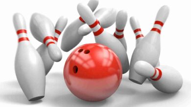 Red bowling ball knocking over pins in a perfect strike