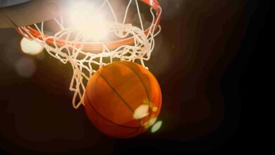 Basketball going through the basket at a sports arena (intention