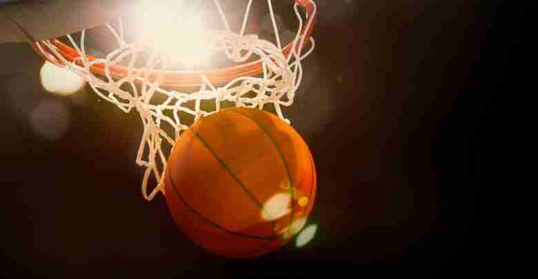 Basketball going through the basket at a sports arena (intention