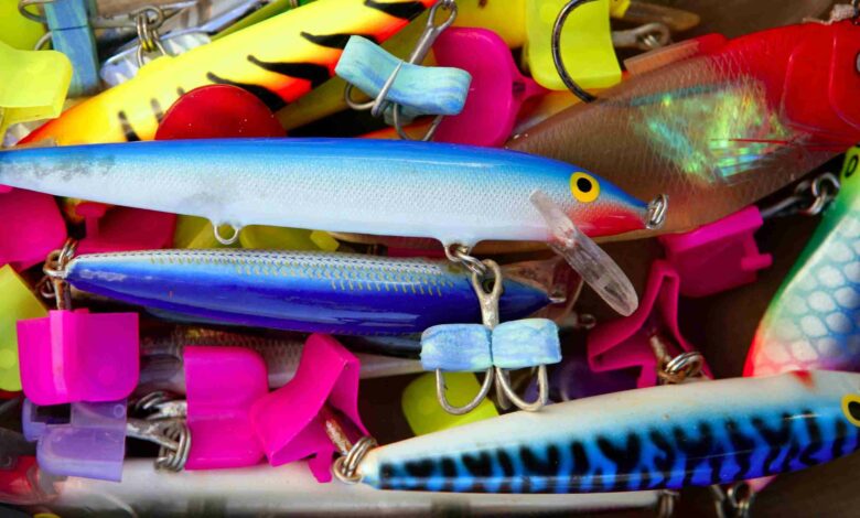 Colorful fishing saltwater fish lures in a box, rusted hooks