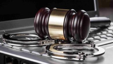 handcuffs and judge gavel on computer concept