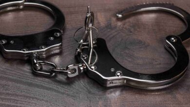 handcuffs and keys on brown wooden table background