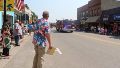 KCHA's Erik Hoefer broadcasts on Main Street during the Charles City Independence Day Parade.