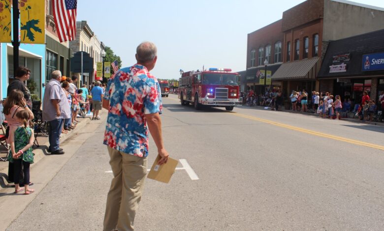 KCHA's Erik Hoefer broadcasts on Main Street during the Charles City Independence Day Parade.
